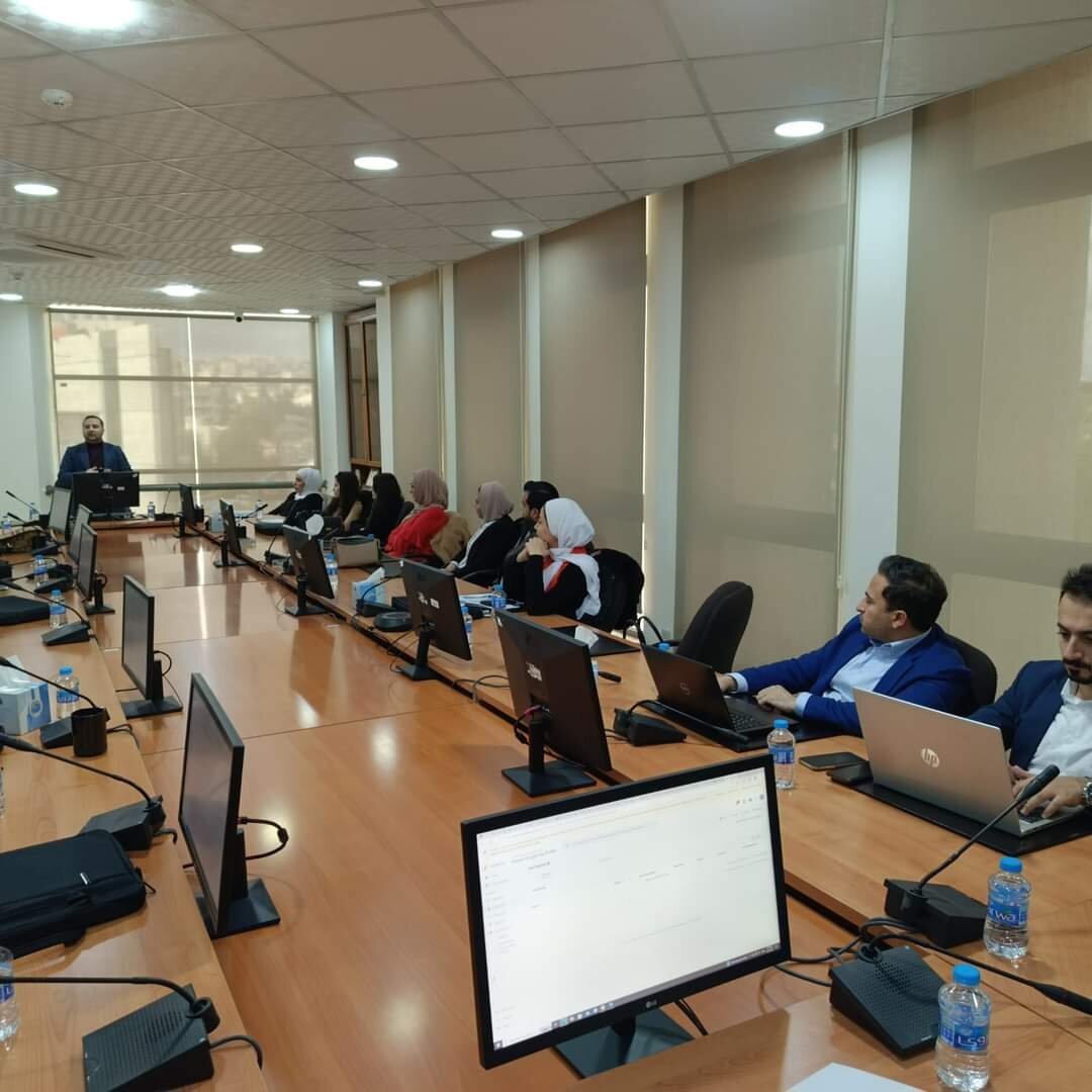 مشاركون يجلسون أمام أجهزة الحاسوب حول طاولة خلال التدريب